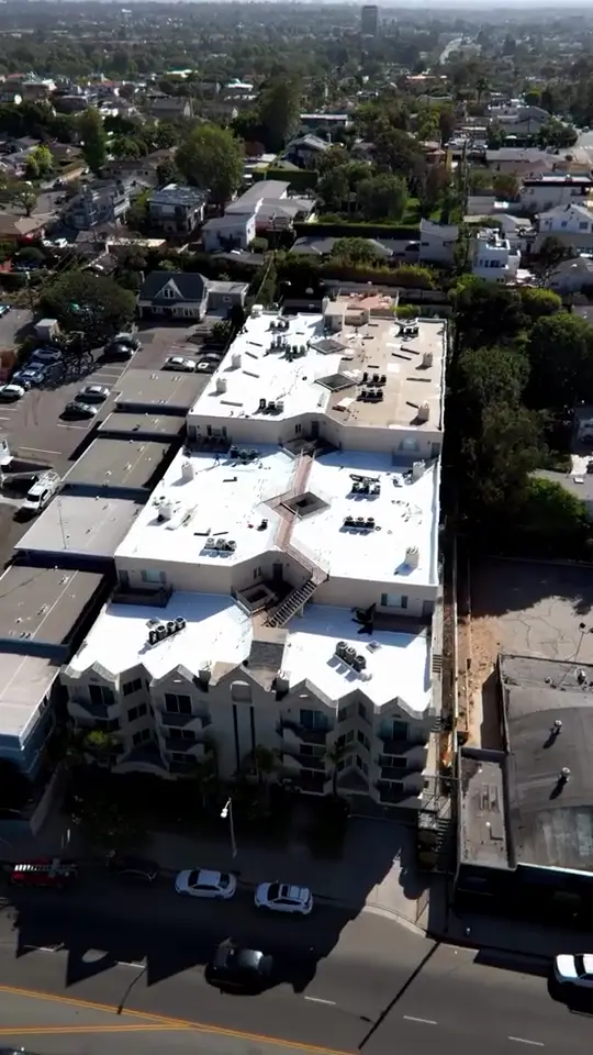 Multifamily TPO — Fresh white TPO across an occupied apartment complex.
